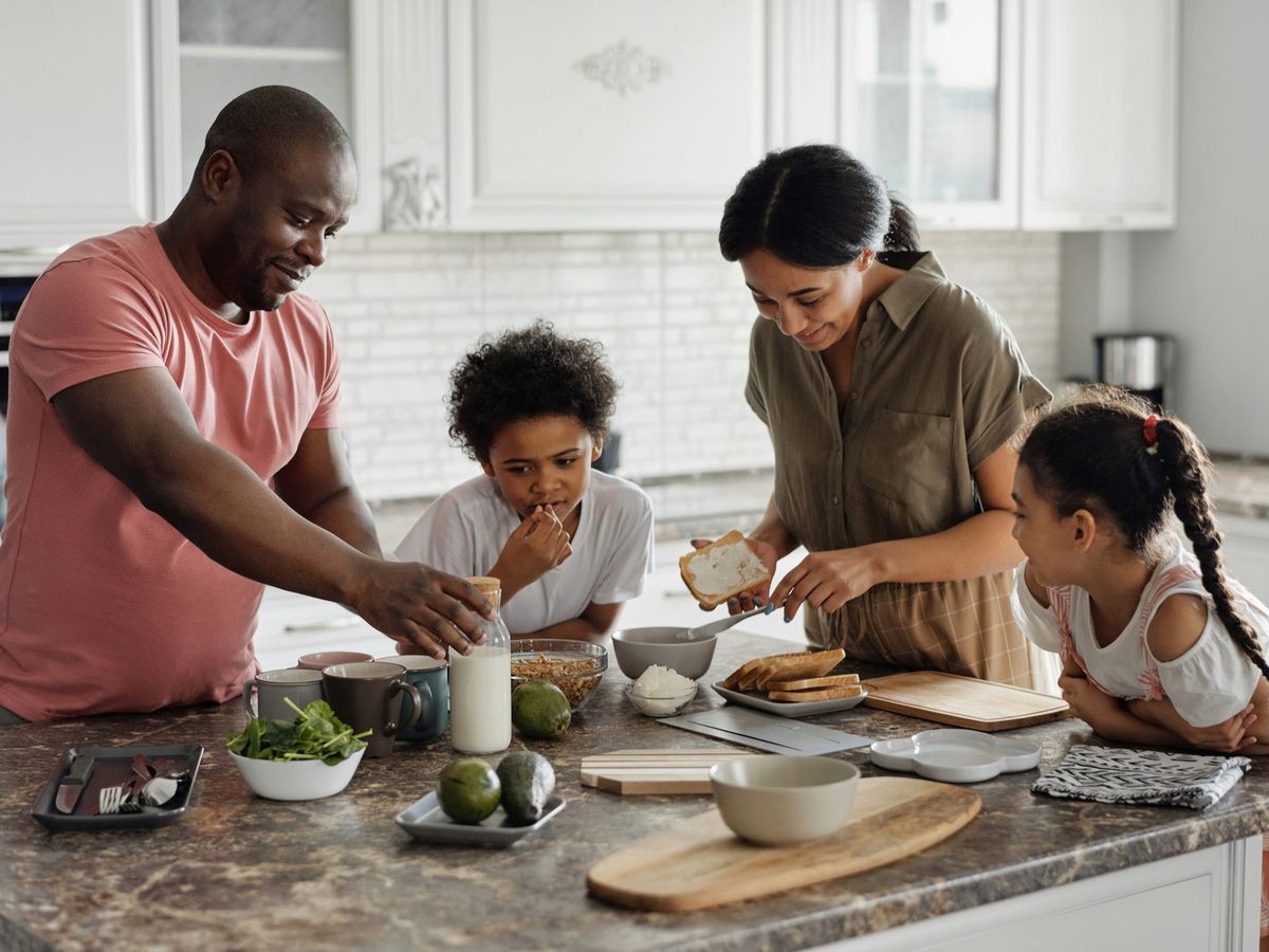 A father preparing breakfast with his kids in a quiet kitchen